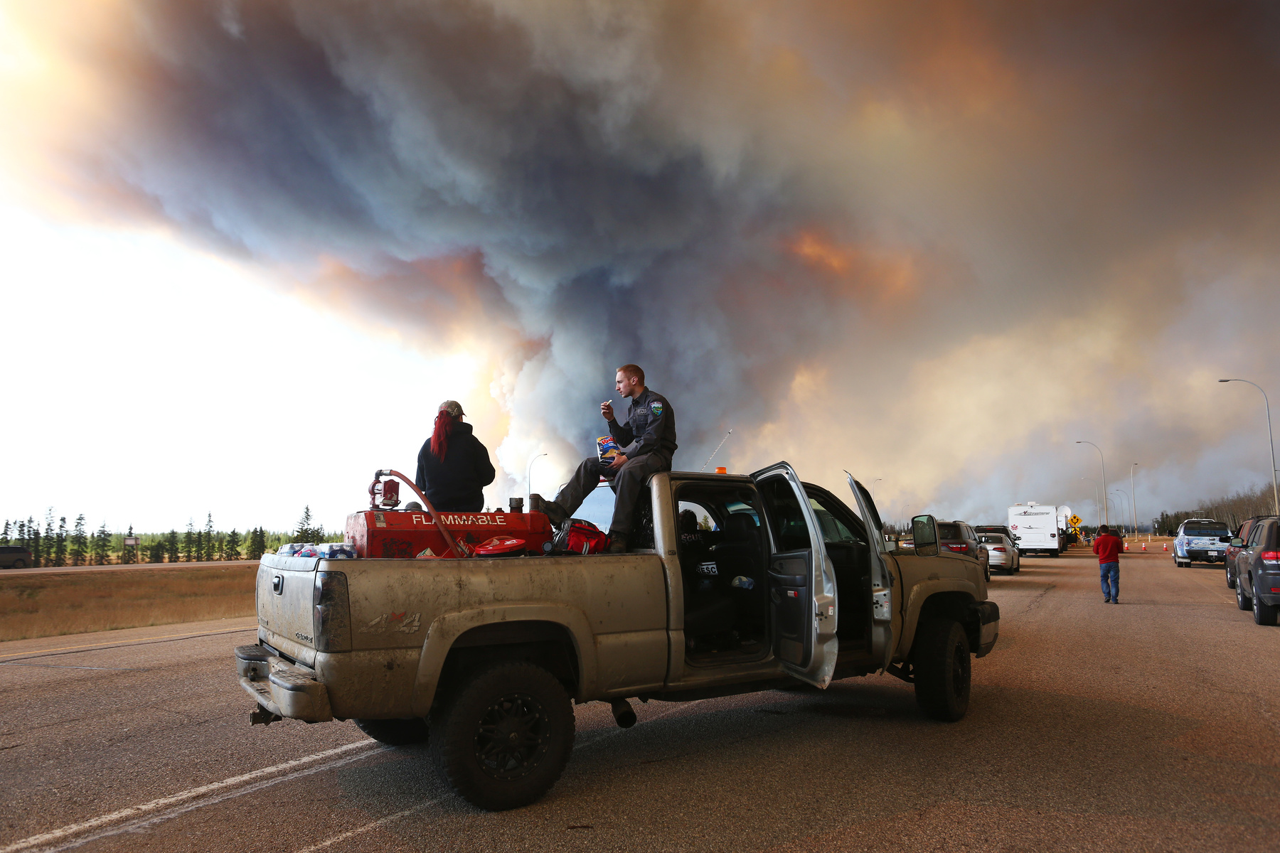  A group trying to rescue animals from Fort McMurray wait at road block on Highway 63 near Fort McMurray, Alberta on May 6, 2016 as smoke billows into the sky from raging forest fires. Photo: Cole Burston